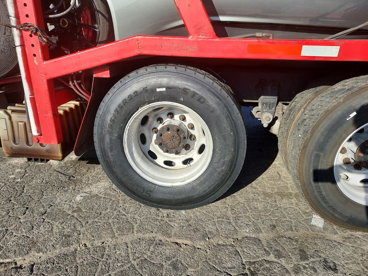 Truck tires on a red trailer, size 295/75R22.5 legible on the sidewall