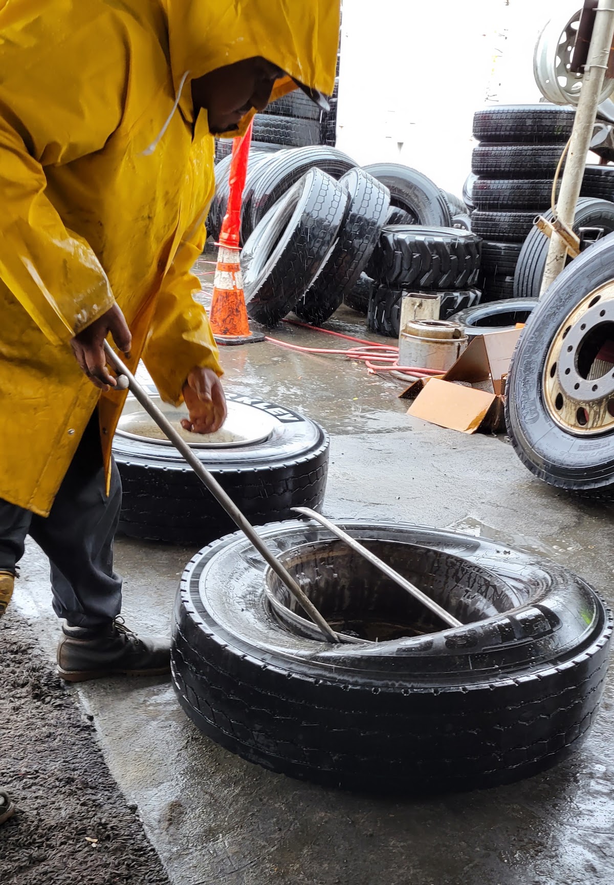 A Valley Commercial Tire technician working a truck tire in the yard